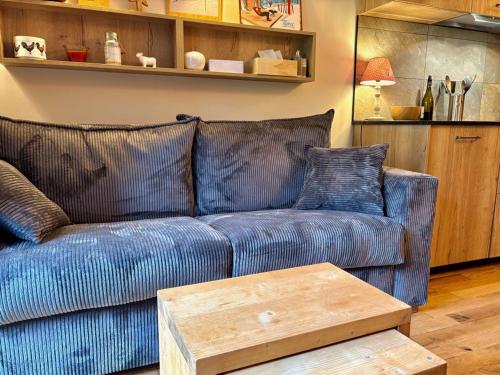 een blauwe bank in een woonkamer met een houten tafel bij RPP C213 - Charmant appt 4pers-Ski aux pieds in Tignes
