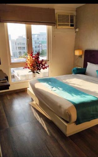 a bedroom with a large bed and a large window at Hotel Gurveer Royal in Lucknow