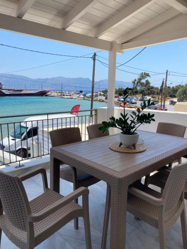 a table and chairs on a balcony with the water at Porto Mare Apartment in Elafonisos