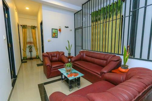 a living room with two leather couches and a table at Castle Resort Yala in Tissamaharama