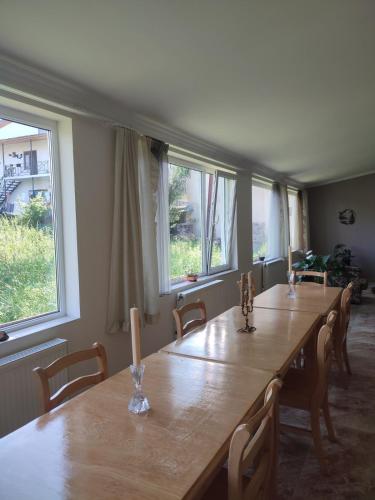 a dining room with a long table and windows at Tuz House R1 in Bakuriani