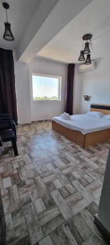 a bedroom with a large bed and a window at Hotel Blue Sky Resort in Eforie Nord