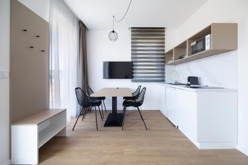 a kitchen and dining room with a table and chairs at Villa Oliver Kehidakustány in Kehidakustány