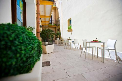 
a patio area with tables, chairs, and umbrellas at Residence Cortile Mercè in Trapani
