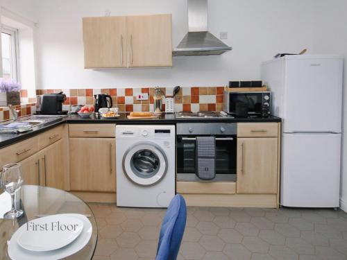 a kitchen with a washing machine and a refrigerator at Inviting 2-Bed apartments - Perfect for Contractors & Business Travellers Parking - Wi-Fi - Netflix in Retford