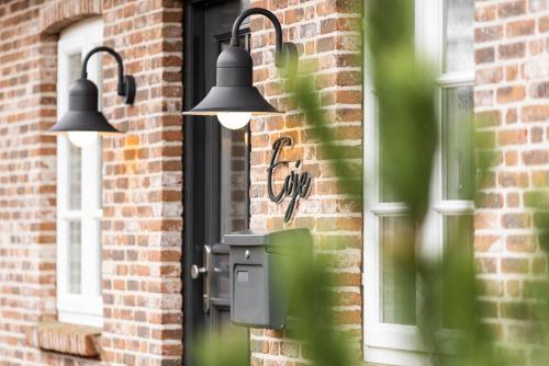 two lights on the side of a building with a window at Haus Evje in Utersum
