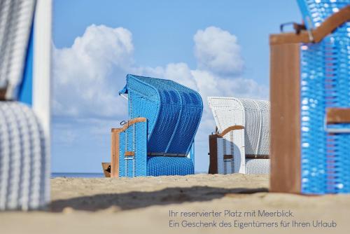 a picture of some chairs in the sand on the beach at Haus Augenblick in Utersum