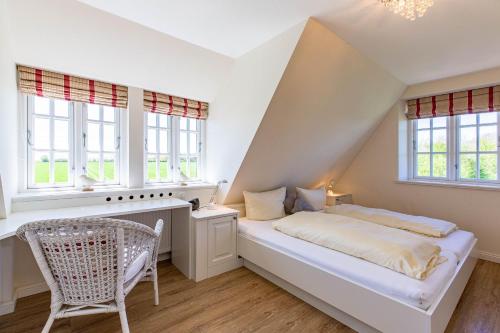 a white bedroom with a bed and a chair at Stine Marie 2 in Borgsum