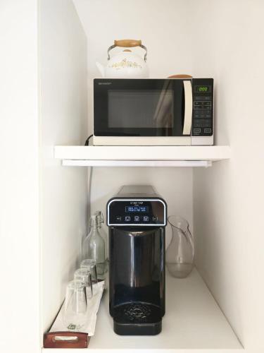 a microwave and a coffee maker on a shelf at Sicily Sea Home in Aci Castello