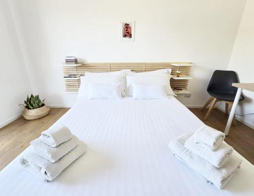 a bedroom with a white bed with towels on it at Sicily Sea Home in Aci Castello