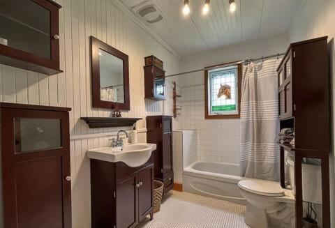 ein Badezimmer mit Waschbecken, Toilette und Badewanne in der Unterkunft La maison des Coteaux in LʼAnse-Saint-Jean