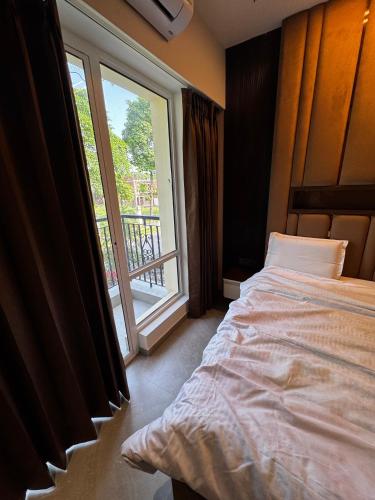 a bedroom with a bed and a large window at Casa Royale An Escape with Elegance in Amritsar
