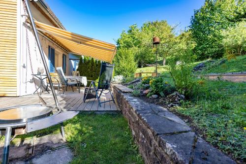 a backyard with a wooden deck with a table and chairs at Paulas Ferienhaus in Buchen