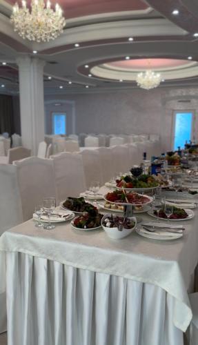 a long white table with plates of food on it at Raffaello in Rostoki