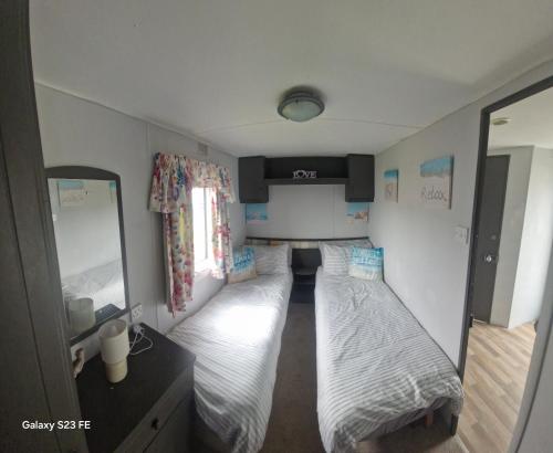 a small room with two beds in it at E11 caravan sand le mere holiday park in Tunstall