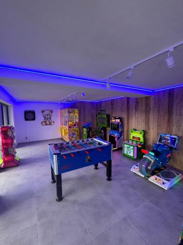 a gaming room with a table and arcade games at Świerkowe Chatki w Koniakowie in Koniaków