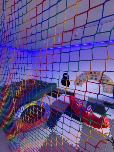 a bedroom with a colorful mesh wall with a bed at Świerkowe Chatki w Koniakowie in Koniaków