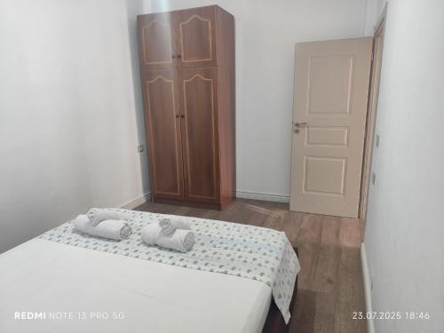 a bedroom with a bed and a wooden cabinet at Beta Holidays in Vlorë