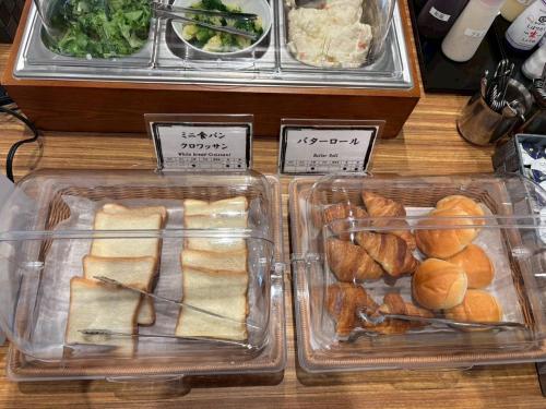 two plastic trays of sandwiches and rolls on a table at Hotel Crown Hills GOI in Ichihara
