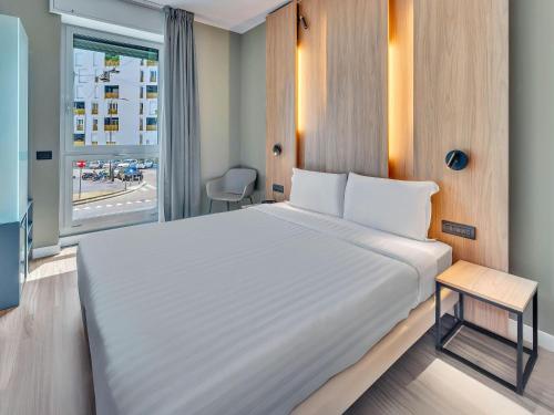 a bedroom with a large white bed and a window at B&B HOTEL Milano Portello in Milan