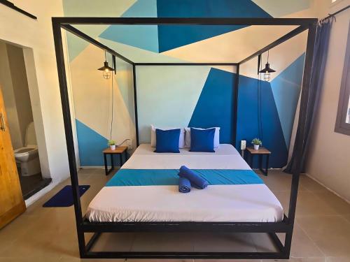 a bedroom with two beds with blue pillows at THE PLACE Hostel Battambang in Battambang