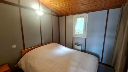 a small bedroom with a bed and a window at Chalet LE LIRY in Tournavaux