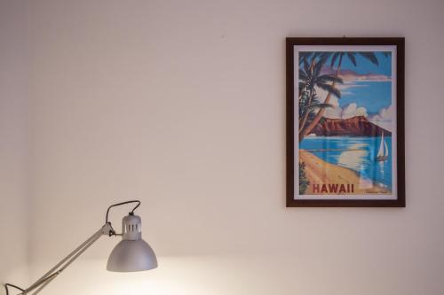 a picture of a palm tree on a wall next to a lamp at Casa del Jazz Historical Center in Piazza Armerina