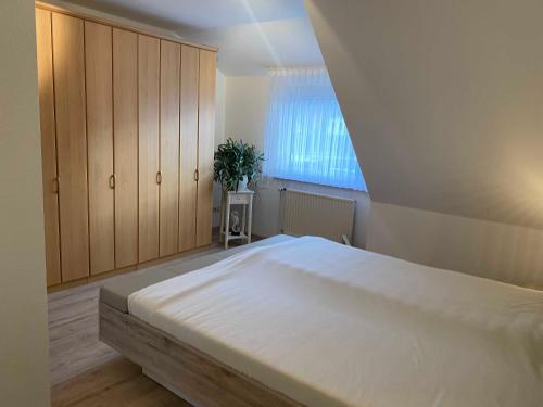 a bedroom with a large white bed with a window at Sonnenkoje in Apensen