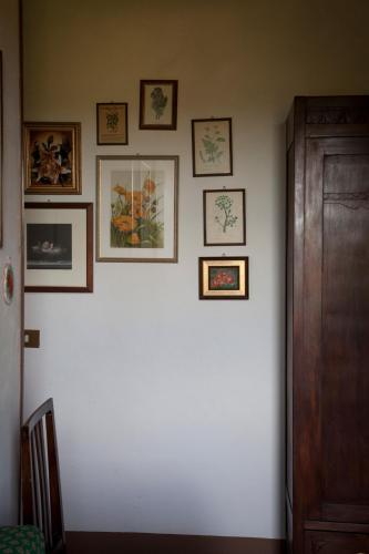 a white wall with framed pictures on it at Agriturismo Santa Maria in Torrita di Siena