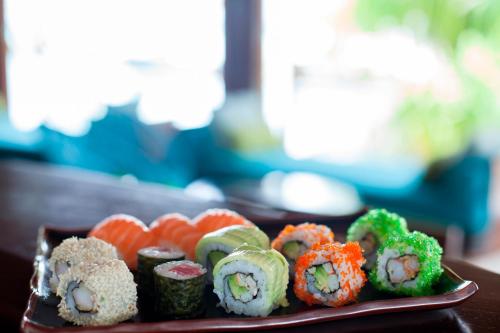 a plate of sushi and vegetables on a table at Constance Halaveli in Hangnaameedhoo