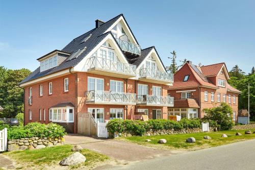 a large red brick building with a balcony at Hardina 1 in Wyk auf Föhr