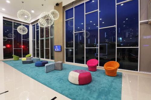 a room with colorful chairs and windows at night at Amerin Hotel Johor Bahru in Johor Bahru