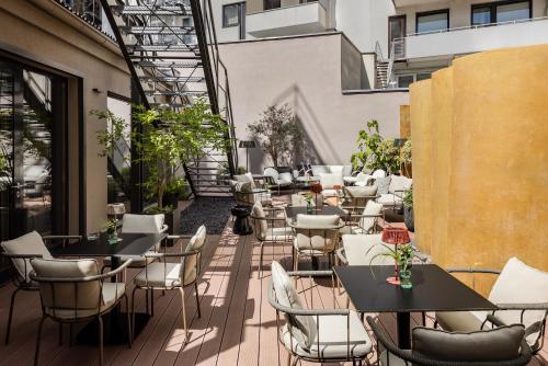 an outdoor patio with tables and chairs on a building at Hotel AMANO Düsseldorf in Düsseldorf