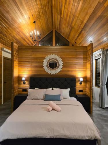 a bedroom with a large bed with a wooden ceiling at Granny's Woods Cottage in Ranau