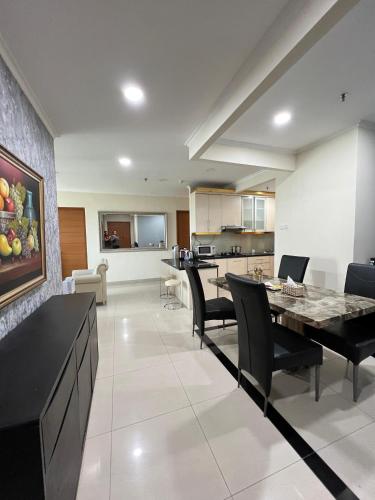 a kitchen and living room with a table and chairs at Spacious living room Hampton's Park Apartment in Jakarta