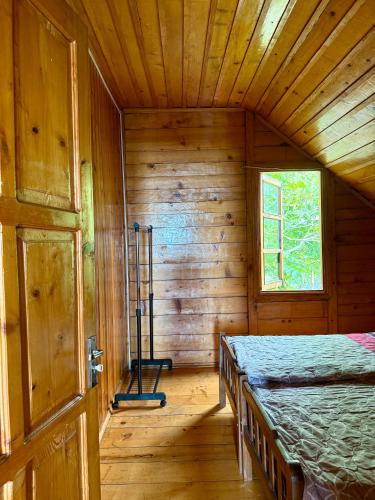 a bedroom with a bed in a wooden cabin at Sunset in Shekvetili in Shekvetili
