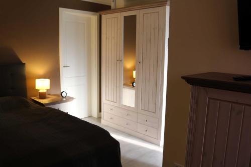 a bedroom with a bed and a cabinet with a lamp at Ferienwohnung zum Schwandter See in Schwandt