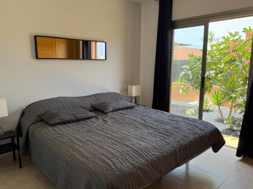 a bedroom with a bed and a large window at Fuerteventura Velvet Golf in Antigua