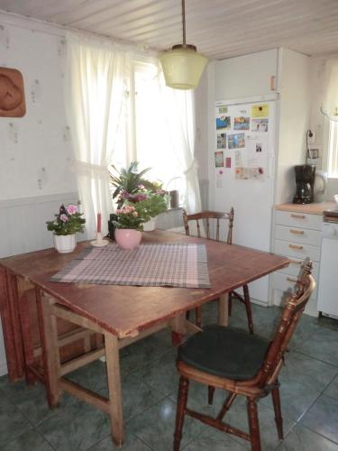 a kitchen with a wooden table with chairs and a tableablish at Träthult, Karlsro med privat badstrand in Edsbruk