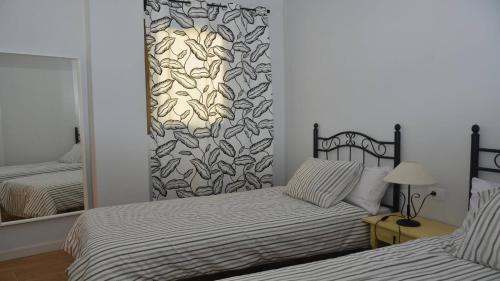 een slaapkamer met twee bedden en een spiegel bij Apt El Molino 3B in Valle Gran Rey