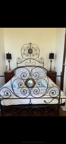 a bedroom with a metal bed with two lamps at Le Château Giat in Giat