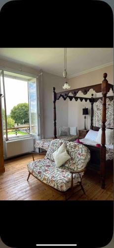 a bedroom with a large bed and a large window at Le Château Giat in Giat