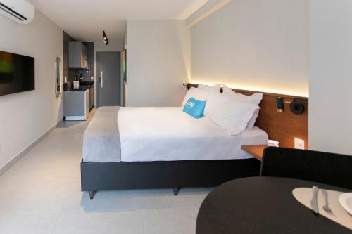 a hotel room with a large bed and a kitchen at Simple Smart By Xtay - Novo, aconchegante e a 7min do Manaíra Shopping in João Pessoa