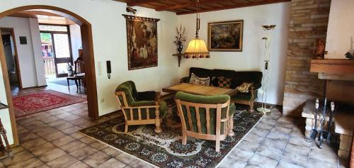 a living room with a couch and a table and chairs at Ferienhaus Korn mitten im schönen Pfälzer Wald, Privat Haus in Bruchweiler-Bärenbach