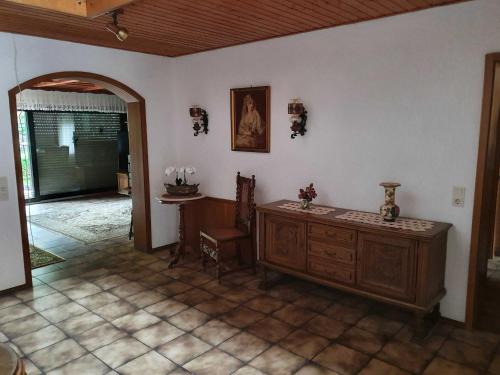 a living room with a wooden dresser and a table at Ferienhaus Korn mitten im schönen Pfälzer Wald, Privat Haus in Bruchweiler-Bärenbach