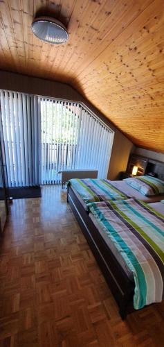 a bedroom with a bed and a wooden ceiling at Ferienhaus Korn mitten im schönen Pfälzer Wald, Privat Haus in Bruchweiler-Bärenbach