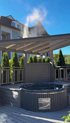 a patio with a hot tub under a wooden deck at Raffaello in Rostoki