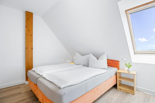 a bed in a room with a window at Ferienhof am Leuchtturm mit Meerbl in Kägsdorf