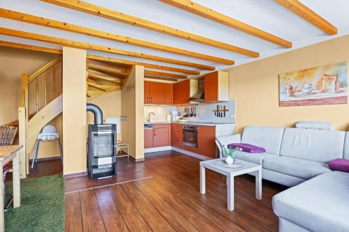 a living room with a couch and a kitchen at Ferienhof am Leuchtturm mit Meerbl in Kägsdorf