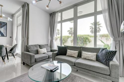 a living room with a couch and a glass table at PVH - Chic 3BR Villa with Backyard - Albizia in Dubai